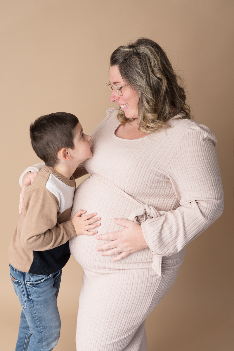 Photographe grossesse Seine-et-Marne, femme enceinte posant en robe de dentelle beige, studio photo proche Fontainebleau.