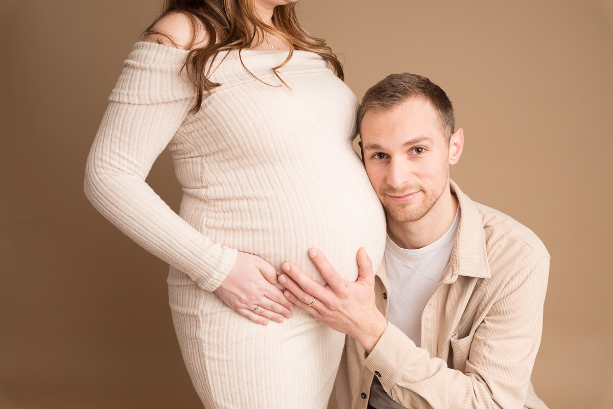 Photographe grossesse Seine-et-Marne, femme enceinte posant en robe de dentelle beige, studio photo proche Fontainebleau.