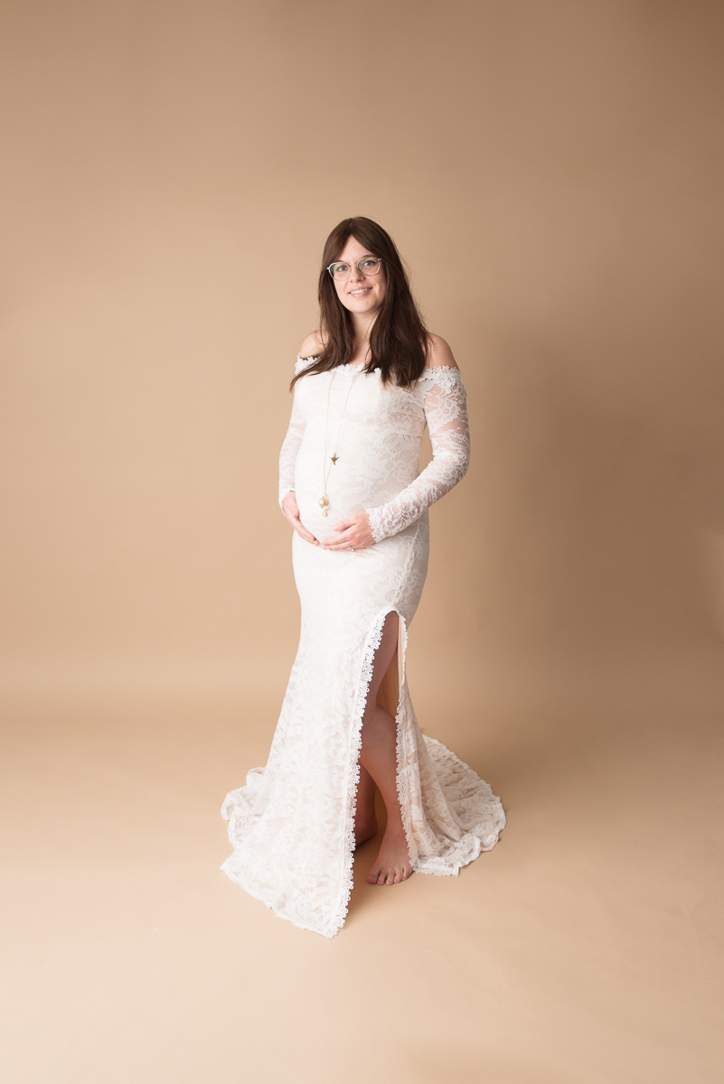 Photo de grossesse artistique, mise en valeur du ventre arrondi sur fond neutre, studio photo professionnel en Seine-et-Marne